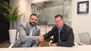 Firma de acuerdo de fundación con Global pack, la imagen muestra dos personas representantes de las empresas dándose la mano